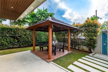 Well-maintained backyard with pergola and luscious greenery