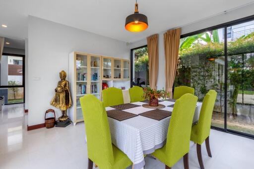 Bright and stylish dining room with green chairs, white table, and modern decor