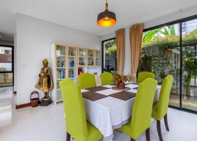 Bright and stylish dining room with green chairs, white table, and modern decor