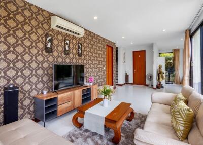 Spacious and elegantly decorated living room with patterned wallpaper and modern amenities