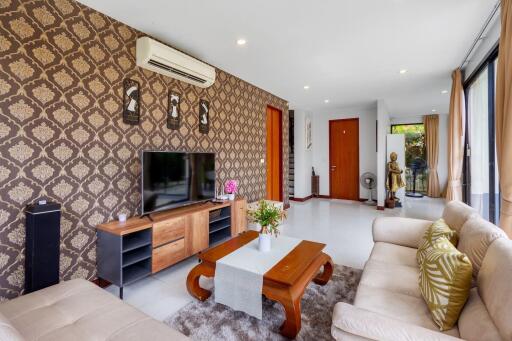 Spacious and elegantly decorated living room with patterned wallpaper and modern amenities