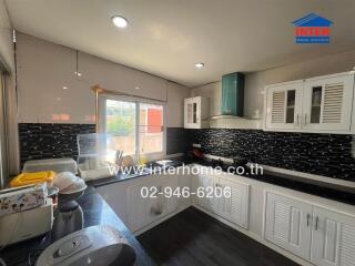 Spacious kitchen with modern appliances and stylish black tiles