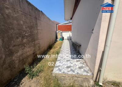 Narrow side yard pathway with tiled flooring in a residential property