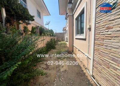 Spacious outdoor side passage of a residential house with decorative stone wall