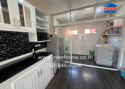 Modern kitchen with white cabinetry and black backsplash