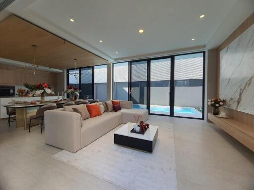 Elegant living room with combined dining area and adjacent kitchen near pool