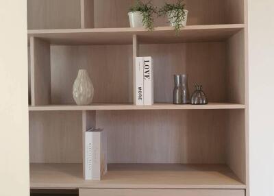 Modern wooden bookshelf in a living room with minimalistic decor
