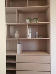 Modern wooden bookshelf in a living room with minimalistic decor