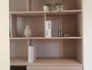 Modern wooden bookshelf in a living room with minimalistic decor
