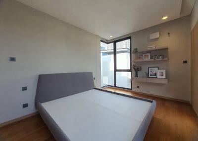 Modern bedroom with large bed, natural light and shelving units