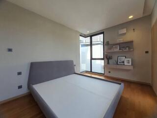 Modern bedroom with large bed, natural light and shelving units