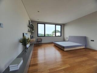 Spacious modern bedroom with large window and hardwood floor