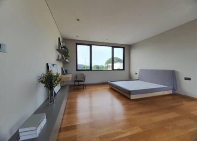 Spacious modern bedroom with large window and hardwood floor