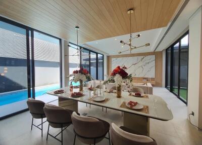 Modern living room with pool view, featuring elegant furniture and natural lighting