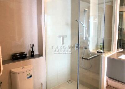 Modern bathroom interior with glass shower and white amenities