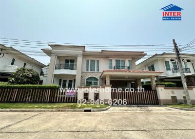 Elegant two-story residential home with a detailed facade and carport