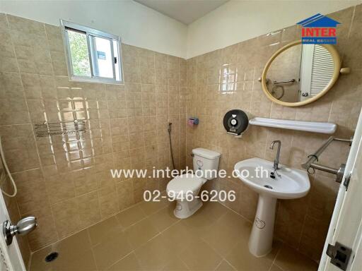 Modern bathroom with beige tiles and natural light