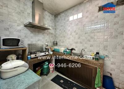 Compact kitchen with appliances and tiled walls