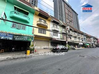 Street view of multi-story residential building with commercial units on the ground floor