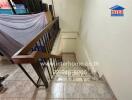 Interior staircase with tiled steps and wooden handrails