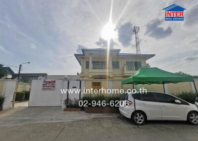 Spacious two-story house with a large driveway and sunny skies