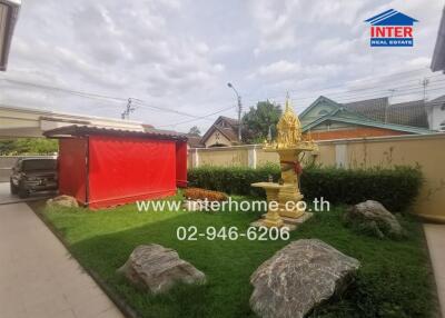 Spacious yard with a golden statue and a red sunshade