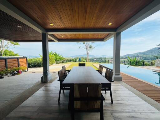 Elegant outdoor dining area with wooden roof and expansive view