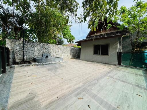 Spacious outdoor courtyard with a stone wall and a small fountain