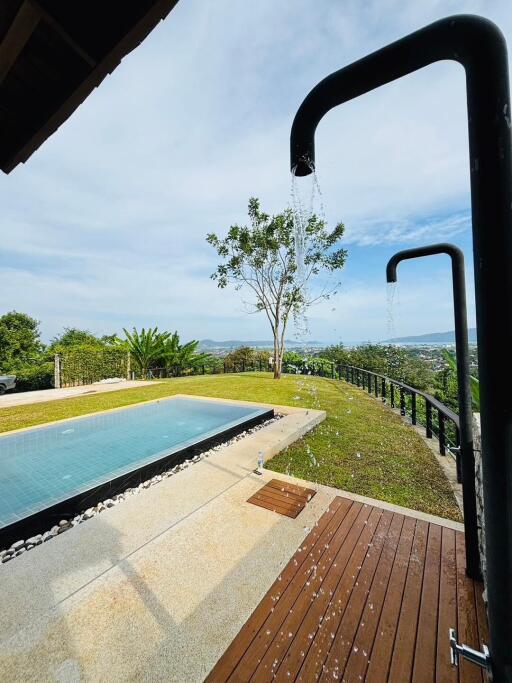 Luxurious hillside pool overlooking scenic landscape with modern outdoor shower