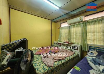 Compact bedroom with air conditioning and bright yellow walls