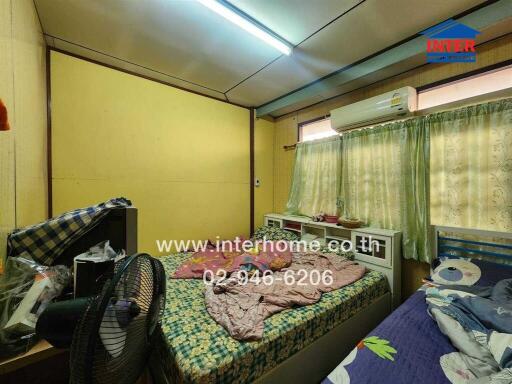 Compact bedroom with air conditioning and bright yellow walls