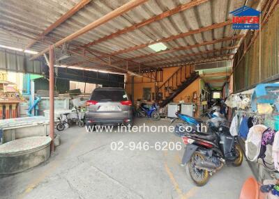 Spacious covered garage with multiple vehicles and storage items