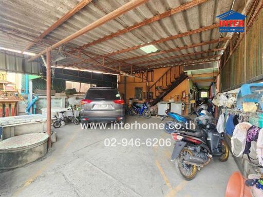 Spacious covered garage with multiple vehicles and storage items