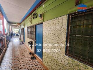 Colorful townhouse exterior with multiple doors and safety grills