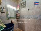 Small, tiled bathroom with storage shelves and mirror