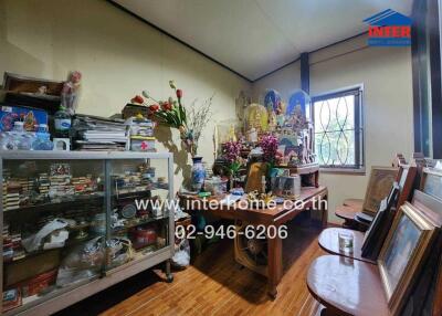 Cluttered living room with shelves and decorative items