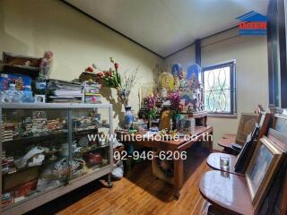 Cluttered living room with shelves and decorative items