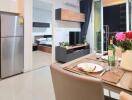 Modern apartment interior with open plan living space featuring kitchen, dining area, and bedroom