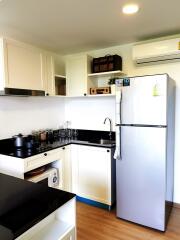 Modern compact kitchen with white cabinetry and stainless steel appliances