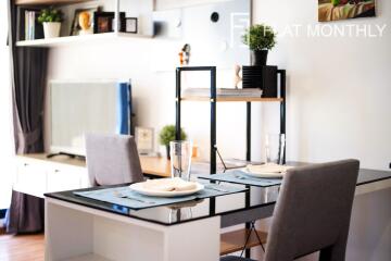 Elegantly set dining table in a modern living space with shelving and decor