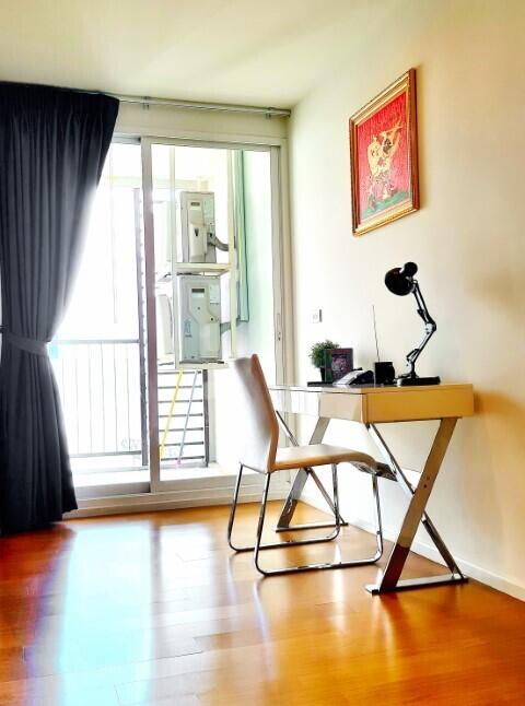 Bright and warmly decorated living space with wooden furniture and balcony access