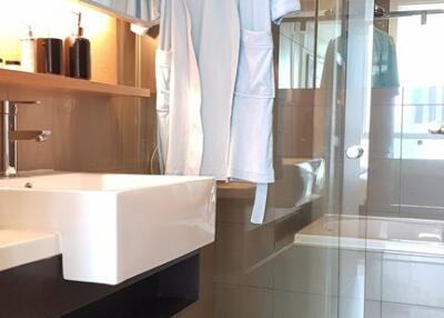 Modern bathroom interior with glass shower and twin bathrobes