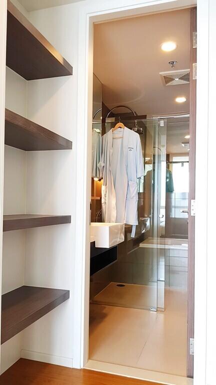 Modern bathroom viewed from hallway with built-in shelves