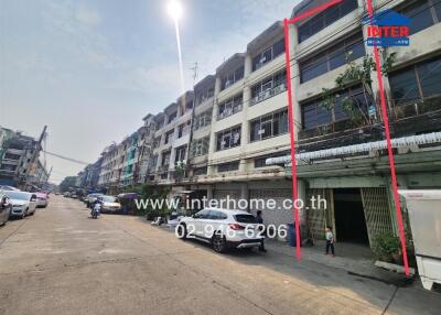 Street view of row of townhouses with individual garages and upper stories, clear sky