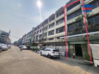 Street view of row of townhouses with individual garages and upper stories, clear sky