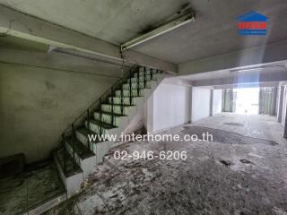 Empty and worn interior of a building with staircase