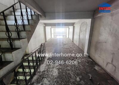 Interior view of a building staircase with concrete walls and metal railings