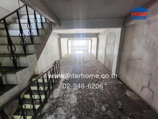 Interior view of a building staircase with concrete walls and metal railings