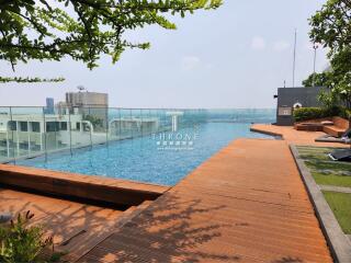 Luxurious rooftop swimming pool with wooden deck and lounge chairs