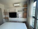 Modern bedroom with large bed, TV, and air conditioning unit
